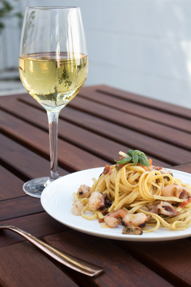 seafood linguine with a glass of wine