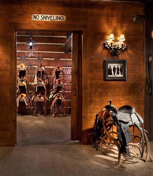 Stunning wooden tack room filled with western saddles