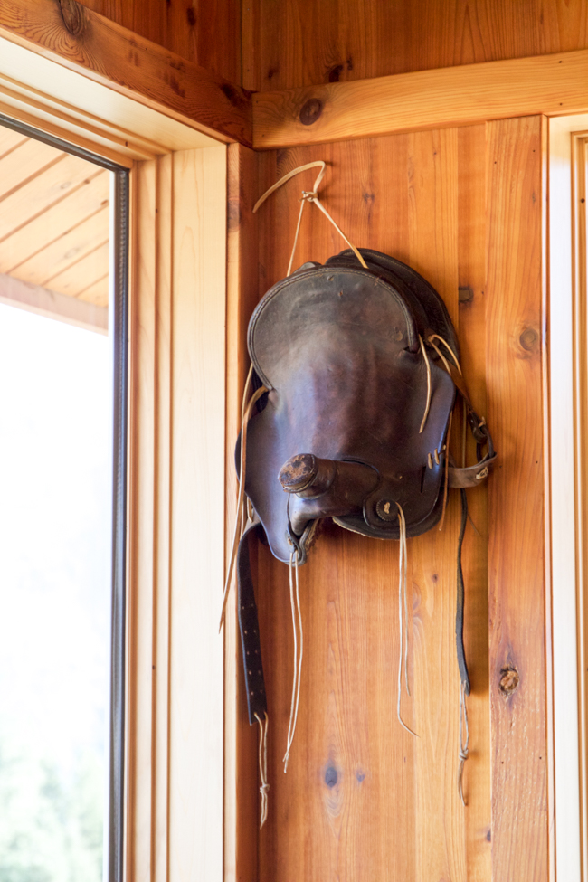 An old western saddle hanging on the wall