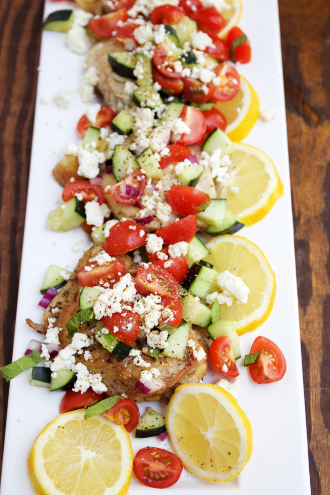 Mediteranean chicken with feta, tomato, and cucumbers. Serve with fresh lemon